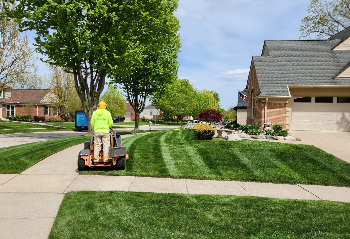 Residential lawn being mowed with clean stripes