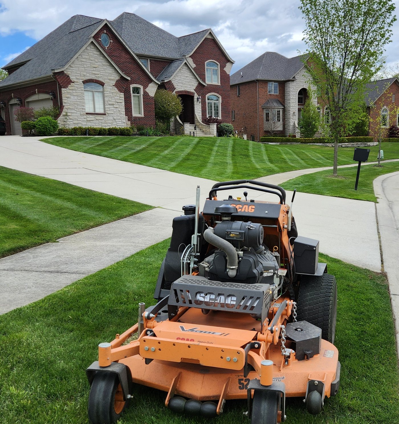 Striped lawn with professional mower in front of a home